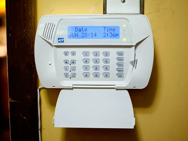 Digital burglar alarm monitoring device installed on wall in Stuart FL home.