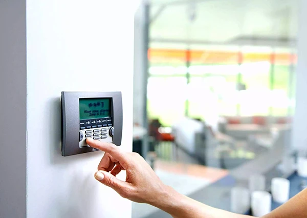 Person using a digital security alarm keypad, illustrating advanced burglar alarm monitoring in Palm Beach Island, FL.