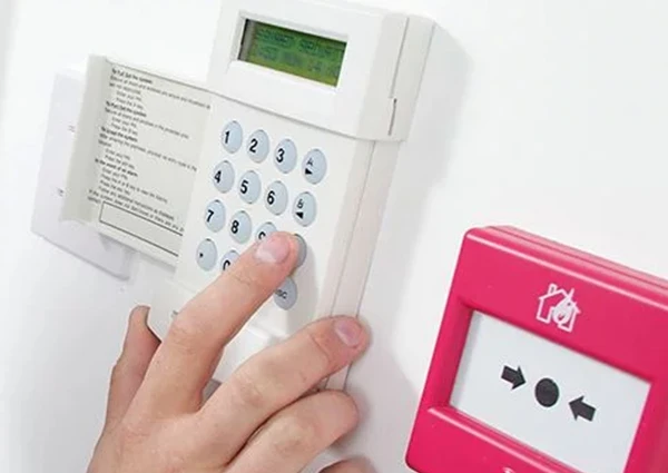 Person operating advanced burglar alarm keypad system in Stuart FL residence.