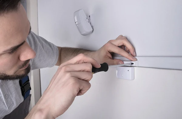 A technician installing advanced sensors on a wall, highlighting professional sensor installation services in Wellington, FL.