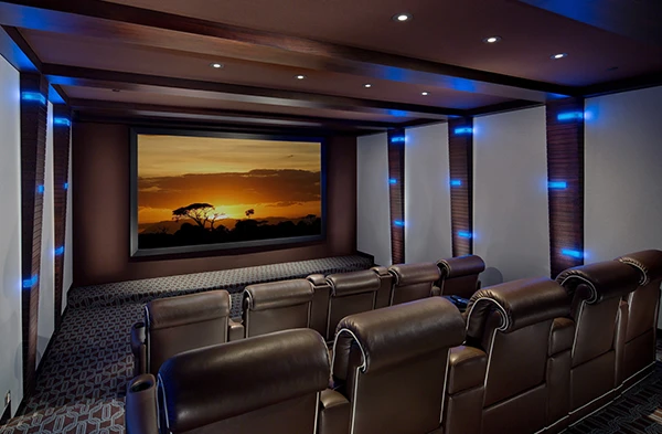 Custom home theater setup with multiple leather chairs and ambient blue lighting.