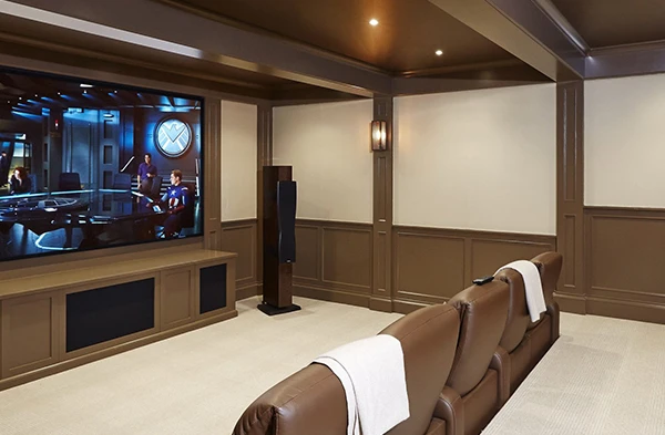 A home theater room setup with large speakers and a projector screen, showing custom home theater installation services in Wellington, FL.