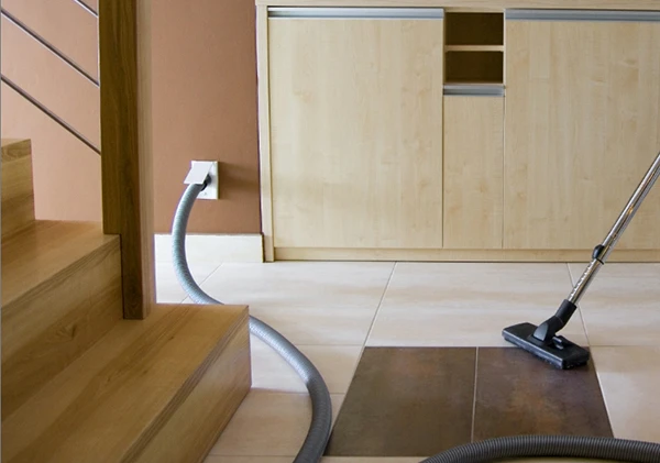 Central vacuum cleaner hose integrated into stairs and wall in a contemporary home.