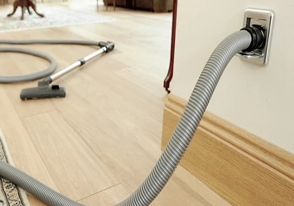A person installing a central vacuum system in a home, demonstrating central vacuum installation services in Wellington, FL.