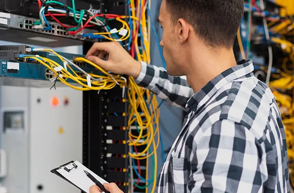 Technician working on network cables and equipment for fast and secure internet installation services in Palm Beach Island, FL.