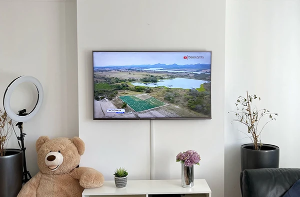 Modern living room with a flat-screen TV wall-mounted above a console table, promoting flawless television mounting services in Palm Beach Island, FL.