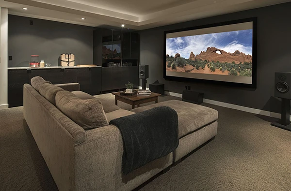 Luxury home theater with projector screen and surround sound system.