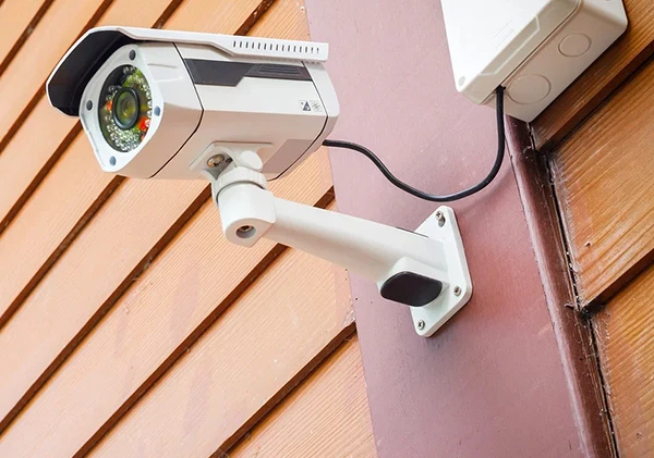 Outdoor security camera mounted on a building exterior for surveillance.