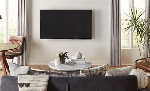Modern living room with a wall-mounted flat-screen television above a fireplace.