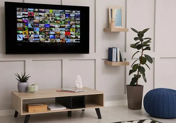 A living room with a mounted flat-screen TV on the wall, showcasing professional television installation in Wellington, FL.