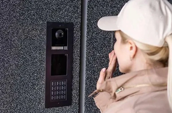 A woman using an intercom system at a residential property in Delray Beach, FL, for enhanced communication and security.