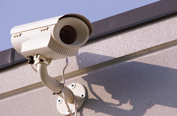 White outdoor security camera mounted on a building exterior for reliable security camera installation services in Palm Beach Island, FL.