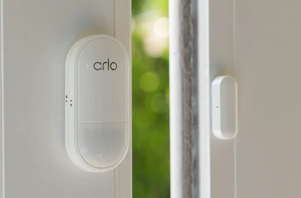 Smart sensor installed on a window frame for motion and environmental monitoring.