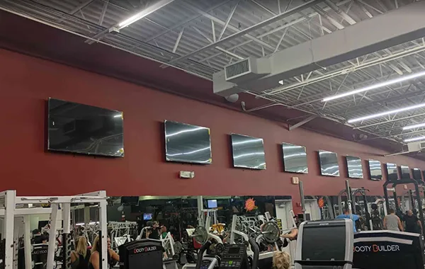 Row of wall-mounted televisions displayed in a large commercial space, illustrating affordable wall-mounted TV installation services in Jupiter, FL.