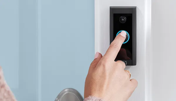 User interacting with Ring smart doorbell for home security and remote monitoring benefits.
