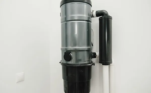 Central vacuum system installation with transparent dirt canister in Royal Palm Beach FL.